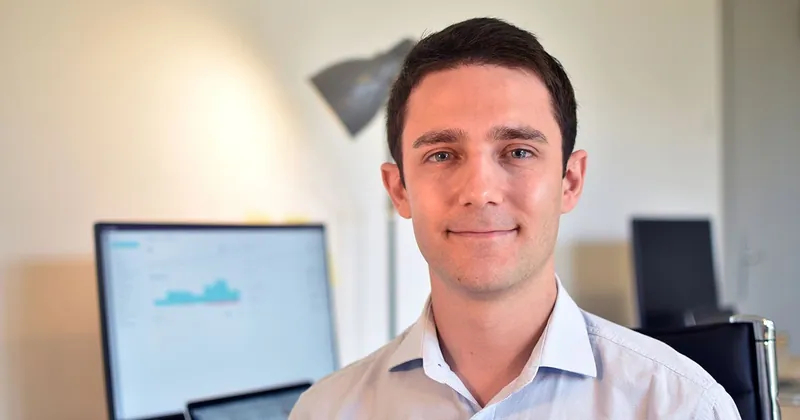 نيك فرانكلين، مؤسس ChartMogul، في مكتبه وخلفه على الشاشة لوحة معلومات للمقاييس