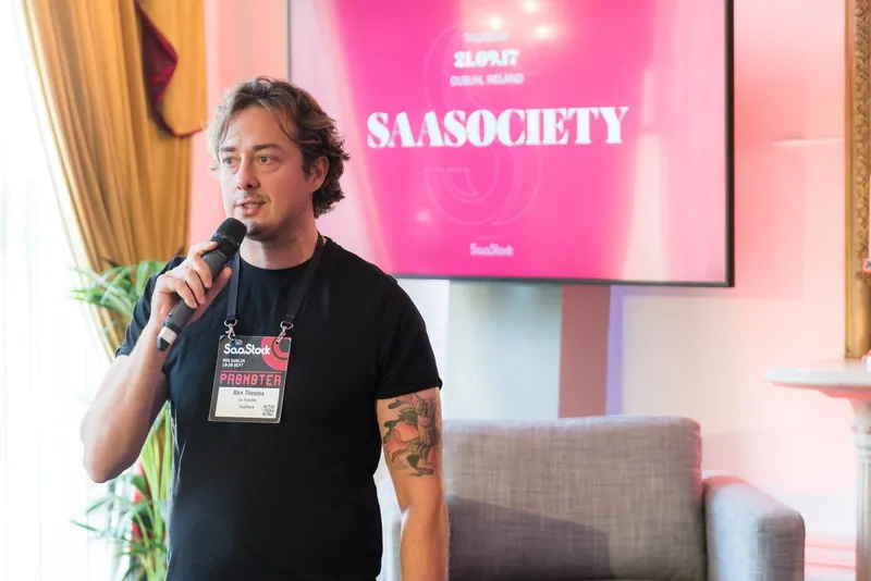 더블린에서 열린 SaaStock SaaSociety 행사에서 마이크를 들고 말하는 Alex Theuma