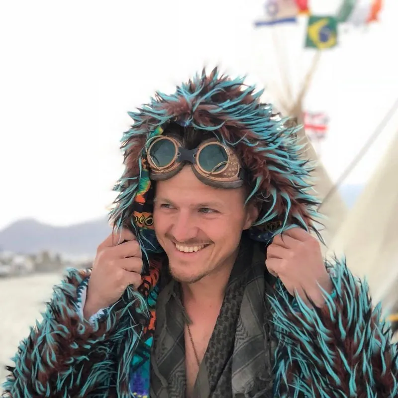 Mikita Mikado of PandaDoc, in a furry coat and goggles at Burning Man
