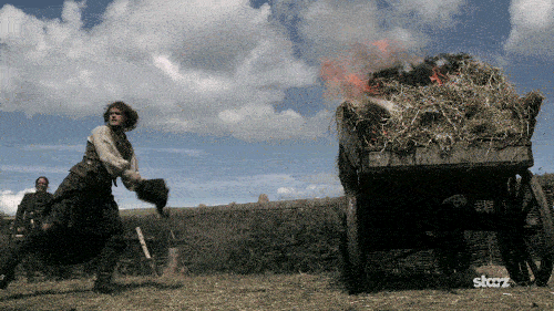 guy throwing bucket of water on a hay fire
